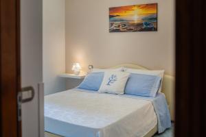 ヴィーコ・エクエンセにあるAquamarine Apartmentのベッドルーム1室(青と白の枕が備わるベッド1台付)