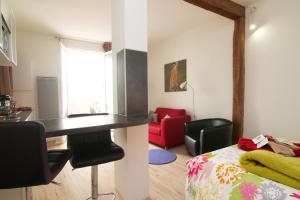 a room with a kitchen and a living room with a bed at Studio Falguiere avec terrasse proche Necker et Montparnasse in Paris