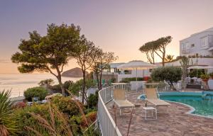 a resort with a pool and chairs and the ocean at Hotel San Giorgio Terme in Ischia