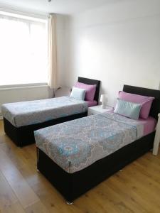 um quarto com 2 camas e uma janela em Dream Time Apartments-Aqua Suite em Londres