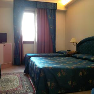 Campagna LupiaにあるHotel Da Vitoのベッド2台と窓が備わるホテルルームです。