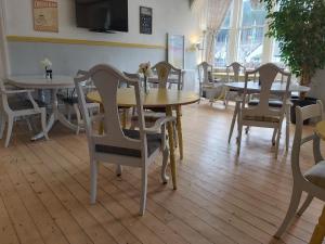 a dining room with tables and chairs and a tv at The Ben Sheann in Strathyre
