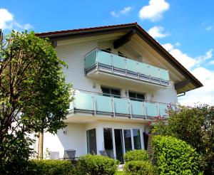 a white house with a balcony on top of it at Chiemsee-Edelweiß Ferienwohnung in Prien am Chiemsee