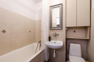 a bathroom with a sink and a toilet and a mirror at Labo Apartment Niska by Old Town in Warsaw