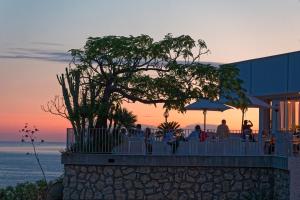 a group of people sitting at a table in front of the ocean at Hotel San Giorgio Terme in Ischia