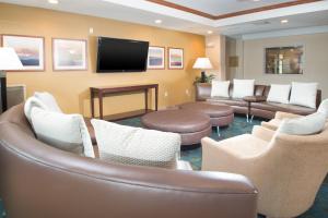 una sala de espera con sofás y TV de pantalla plana. en Candlewood Suites Wake Forest-Raleigh Area, an IHG Hotel, en Wake Forest