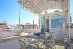 un patio con tavolo e sedie su un balcone di TD Dimora Arcadia with Breathtaking Sea View a Monopoli