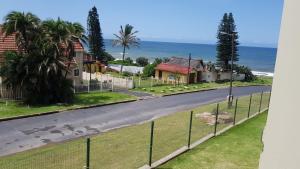 a road with houses and the ocean in the background at Saints View Resort Unit 9 in Uvongo Beach