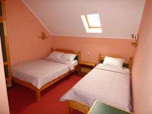 a small room with two beds and a skylight at Vila Palma Palic in Palić
