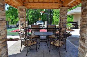 un patio con una mesa y sillas y un aro de baloncesto en Staybridge Suites North Jacksonville, an IHG Hotel en Jacksonville