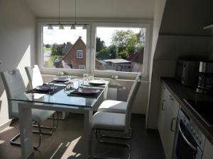a kitchen with a table with chairs and a window at Ferienwohnung Zwischen Marsch u. Geest in Eddelak