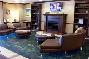 a waiting room with couches and a fireplace at Candlewood Suites Youngstown W - I-80 Niles Area, an IHG Hotel in Austintown