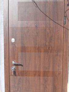 a brown door with a handle on it at Жилье отдельное in Odesa