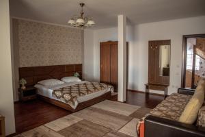a bedroom with two beds and a couch at Pensiunea Eden in Ranca