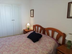 a bedroom with a bed with a black pillow on it at La Marina Solo Familias!!! Serviplaya in Playa de Xeraco