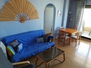 a living room with a blue couch and a table at La Marina Solo Familias!!! Serviplaya in Playa de Xeraco