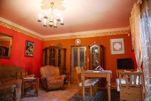 ein Wohnzimmer mit orangefarbenen Wänden sowie einem Tisch und Stühlen in der Unterkunft Bydleni u Babicky in Bratronice