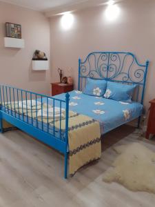 una camera da letto con un letto blu con cuscini blu di Skyline Central Apartment a Timişoara