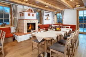 a dining room with a fireplace and tables and chairs at Apartmány Roháče in Zuberec