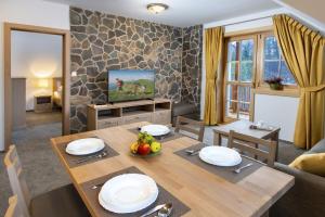 Apartmány Roháče في زوبيريتس: غرفة معيشة مع طاولة طعام وتلفزيون
