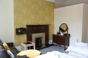 a living room with a fireplace and a mirror at The Darnley Hotel in Ilfracombe