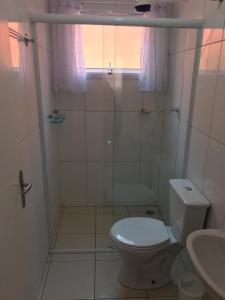 um banheiro com chuveiro, vaso sanitário e pia em Apartamento Boracéia Bertioga em Bertioga