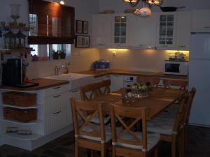 a kitchen with a wooden table and a kitchen with white cabinets at Calma in Perdika