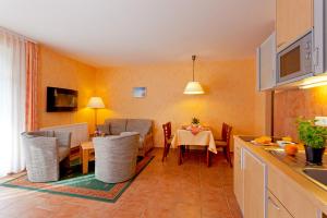eine Küche und ein Esszimmer mit einem Tisch und Stühlen in der Unterkunft Strandvilla Alessandra in Trassenheide