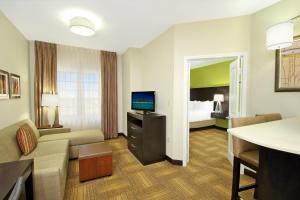 a hotel room with a couch and a television at Staybridge Suites - Odessa - Interstate HWY 20 by IHG in Odessa