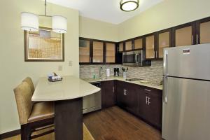 a kitchen with a table and a refrigerator at Staybridge Suites - Odessa - Interstate HWY 20 by IHG in Odessa