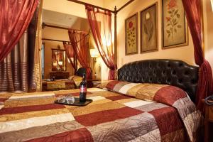 Un dormitorio con una cama con una botella de vino. en Exis Hotel, en Atenas
