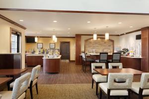 a dining room and kitchen with tables and chairs at Staybridge Suites Midland, an IHG Hotel in Midland