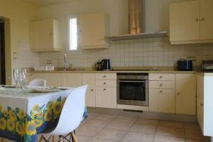 uma cozinha com uma mesa e um fogão forno superior em La Vue D'Or em La Roque-Gageac