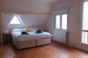 um quarto com uma cama e duas janelas em La Vue D'Or em La Roque-Gageac