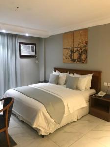 1 dormitorio con 1 cama blanca grande en Durrat Arak furnished apartments en Yeda