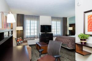a hotel room with a bed and a living room at Staybridge Suites Lincoln North East by IHG in Lincoln