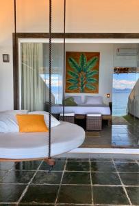 Cama colgante en una habitación con vistas al océano en Casa da Ilha, en Praia de Araçatiba