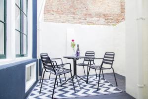a patio with chairs and a table with a vase on it at Appartement Middelburg4you in Middelburg