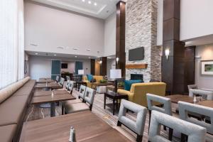 a restaurant with tables and chairs and a fireplace at Staybridge Suites - Lake Jackson, an IHG Hotel in Lake Jackson