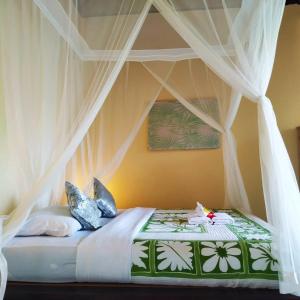 a bed with a canopy in a room at Kanda Homestay in Sidemen