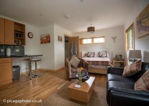 a living room with a couch and a bed at Loch Ness Studio Blairbeg in Drumnadrochit