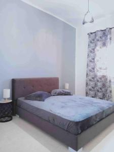 una camera da letto con un grande letto in una stanza bianca di Appartement Manzah 6 a Ariana