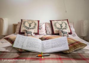 an open book sitting on top of a bed at Loch Ness Studio Blairbeg in Drumnadrochit