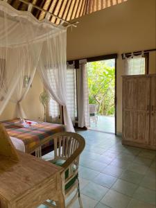 a bedroom with a bed with a mosquito net at Kanda Homestay in Sidemen