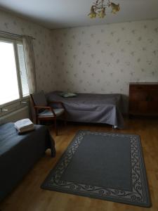 1 dormitorio con 2 camas, silla y alfombra en Kouvola Guest house en Kouvola