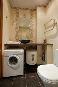 a bathroom with a washing machine and a toilet at OK! Советская, 69 №9 in Tomsk