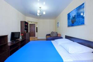 a bedroom with a large bed with a blue light at OK! Советская, 69 №9 in Tomsk