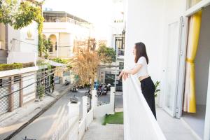 芹苴的住宿－MIDMOST Villa Hotel，站在一个眺望着街道的阳台上的女人