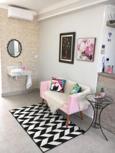 a living room with a pink couch and a table at Pousada Della Nonna in Presidente Prudente