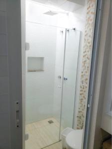 a bathroom with a glass shower with a toilet at Pousada Della Nonna in Presidente Prudente